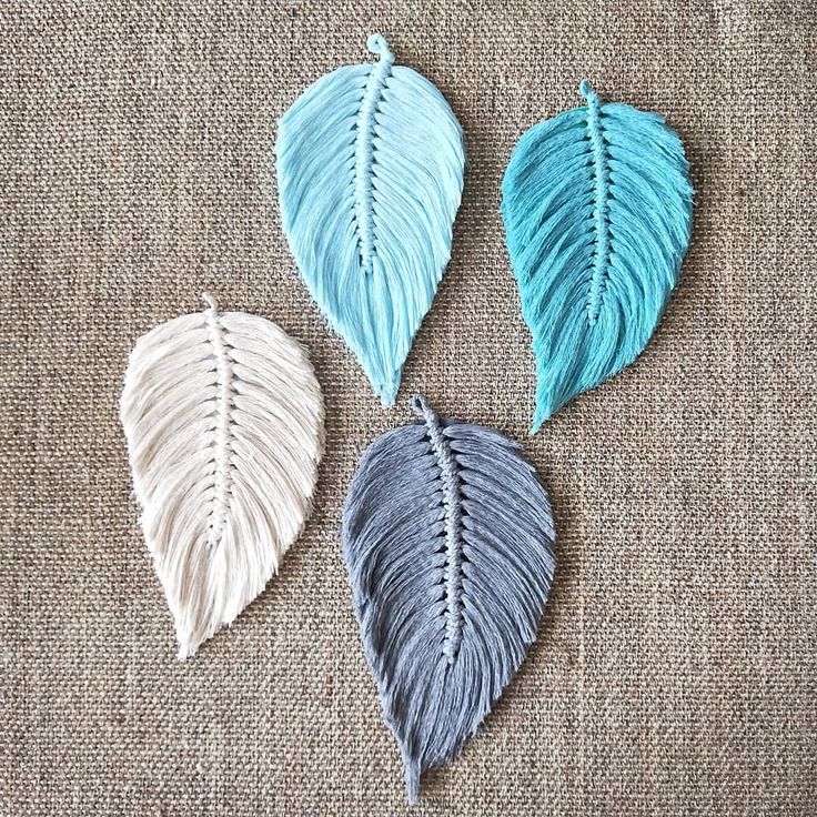 three different colored leaves sitting on top of a cloth covered surface, one is white and the other is blue