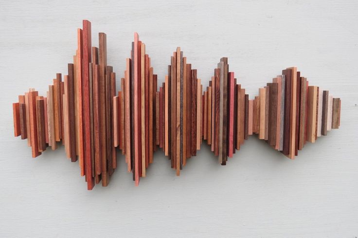 a sculpture made out of wood sticks on a white surface