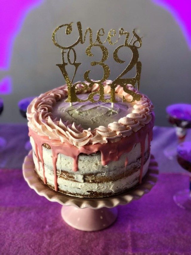 there is a cake that has been decorated with pink icing and gold letters on it