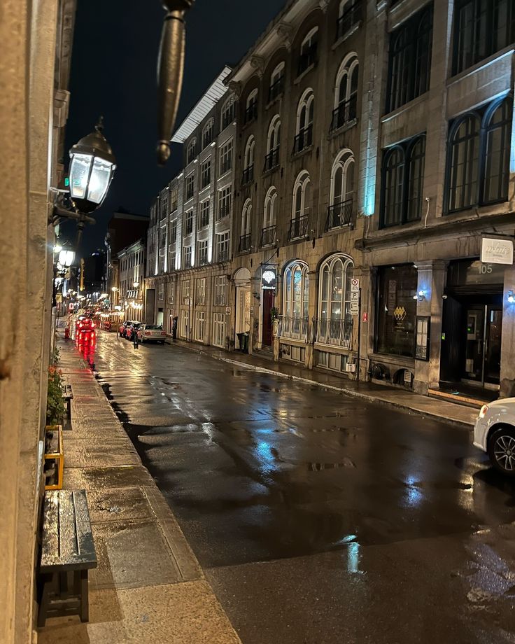 an empty city street at night with rain on the ground