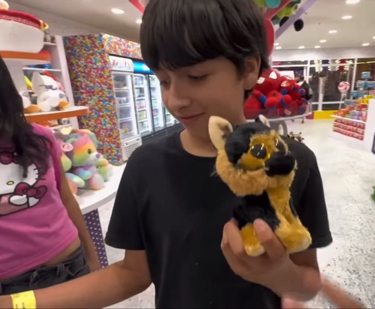 a young boy holding a stuffed animal in his hand