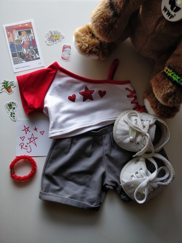 a teddy bear sitting on top of a table next to some shoes and other items