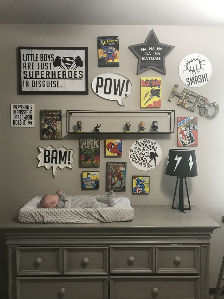 a baby is laying in his crib with many pictures on the wall