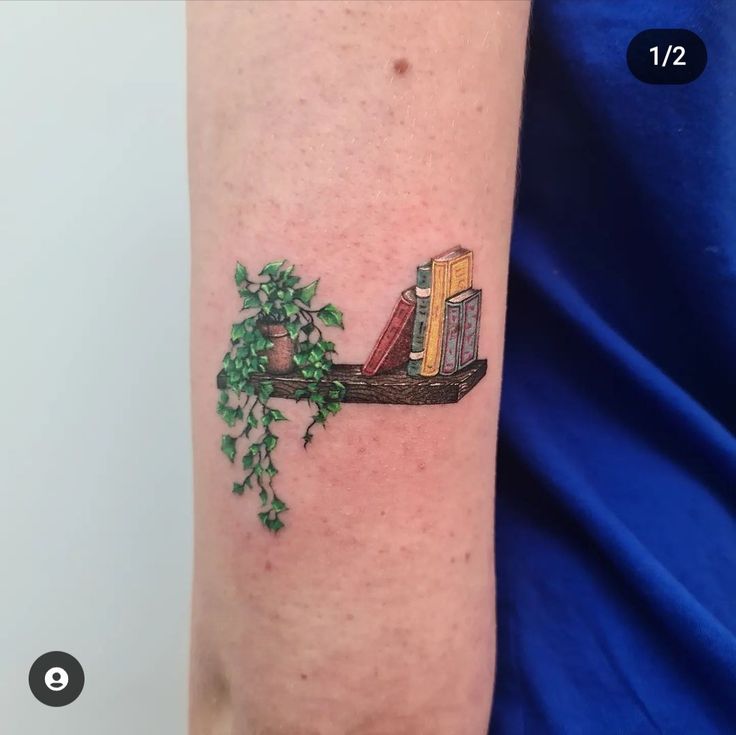 a tattoo on the arm of a person with books and plants growing out of them