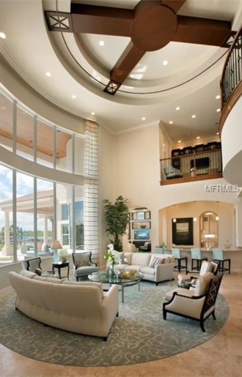 a living room filled with furniture and large windows