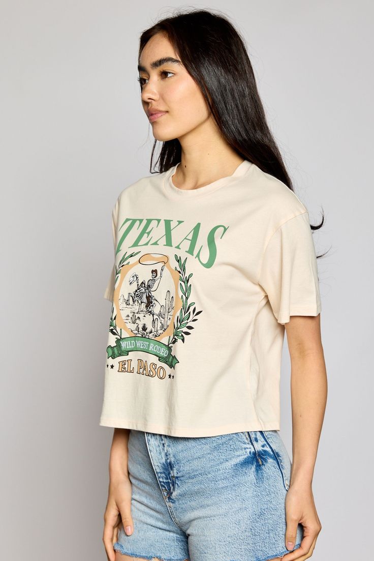 This Texas Wild West Rodeo tee has serious swagger! Featuring "TEXAS WILD WEST RODEO" print and an embroidered short sleeve crop top, this bad boy will make you the envy of the honky tonks! Saddle up and get ready to ride in style! 🤠 100% Cotton Cropped Cotton T-shirt With Text Print, Screen Print Cotton Cropped T-shirt, Casual Cropped Text Print T-shirt, Cotton Cropped Shirt With Text Print And Short Sleeves, Cotton Graphic Tee Crop Top With Screen Print, Relaxed Fit Short Sleeve Screen Print Crop Top, Retro Cropped Cotton T-shirt, Graphic Tee Style Cotton Crop Top With Screen Print, Casual Cropped T-shirt With Screen Print