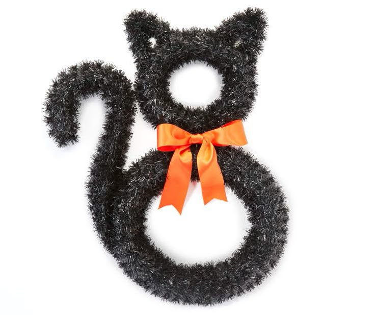 a black cat with an orange bow on its head and tail is sitting in front of a white background