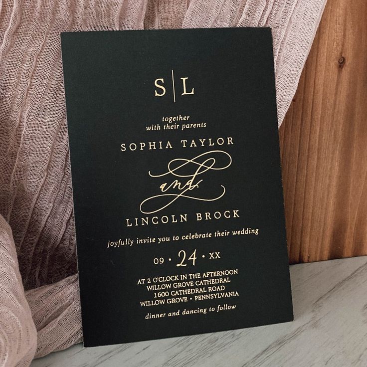 a black and gold wedding card with the word sl written in cursive font