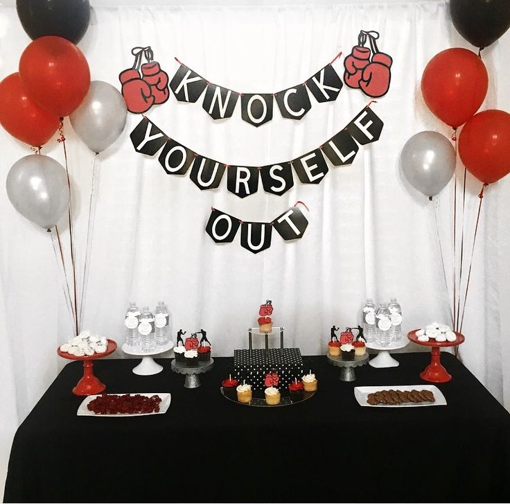 a black table topped with desserts and balloons