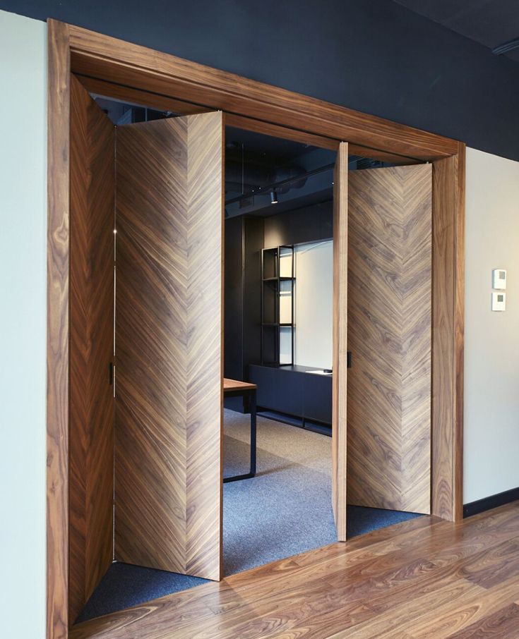 an empty room with wooden doors and hard wood flooring