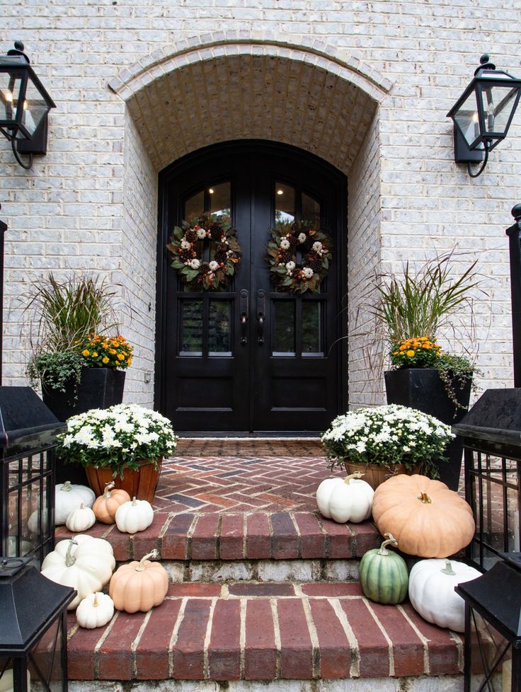 the front steps are decorated with pumpkins and gourds