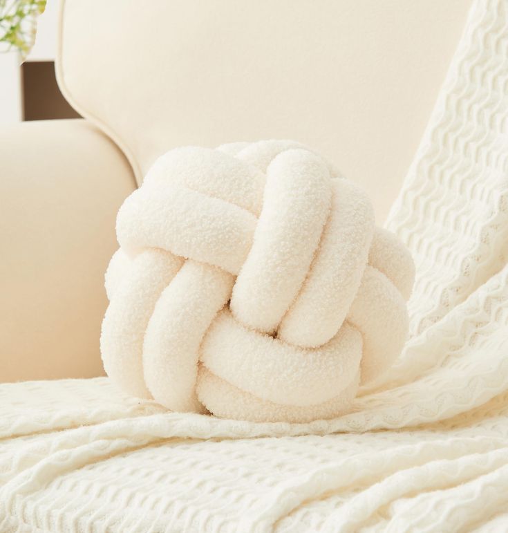 a pile of white towels sitting on top of a couch