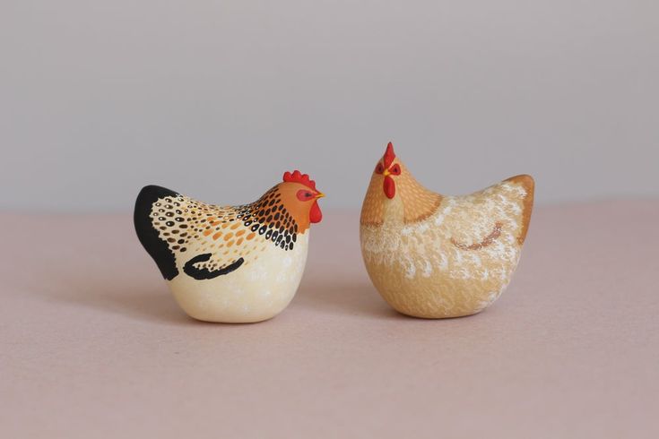 two ceramic chickens sitting next to each other