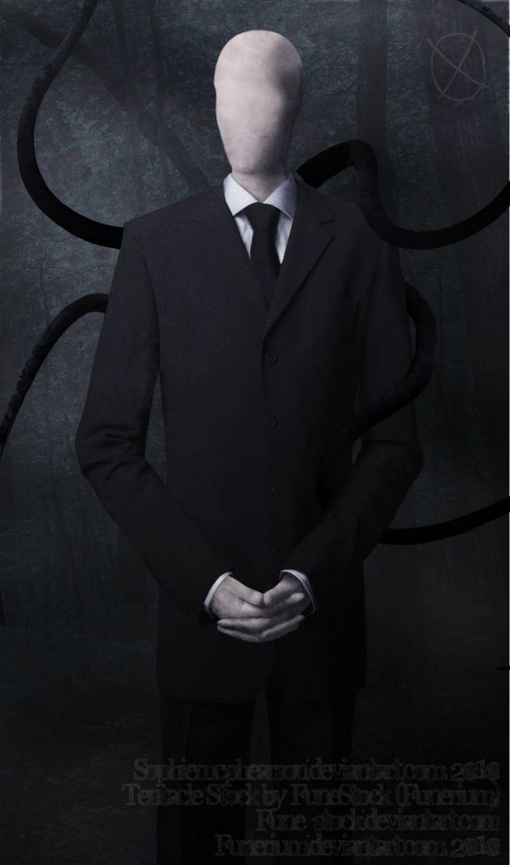 a man in a suit and tie standing with his hands on his hips while wearing a creepy mask