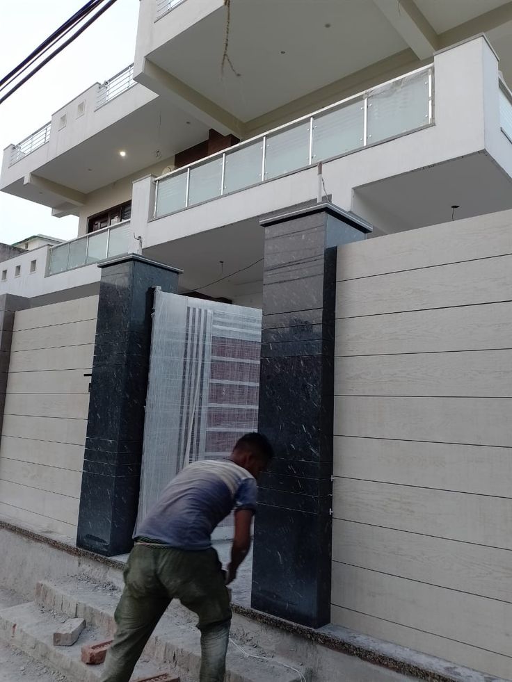 a man climbing up the side of a building to pick up something from the ground