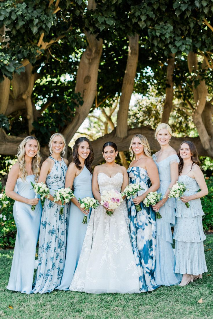 a group of women standing next to each other on top of a lush green field