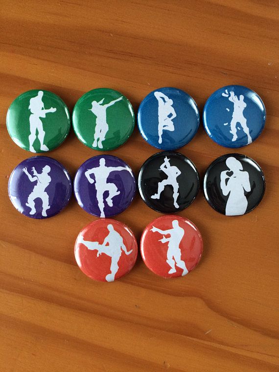 six buttons with the silhouettes of people in different colors and sizes, on a wooden surface