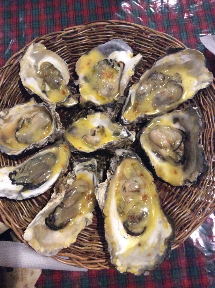 a basket filled with lots of oysters on top of a table