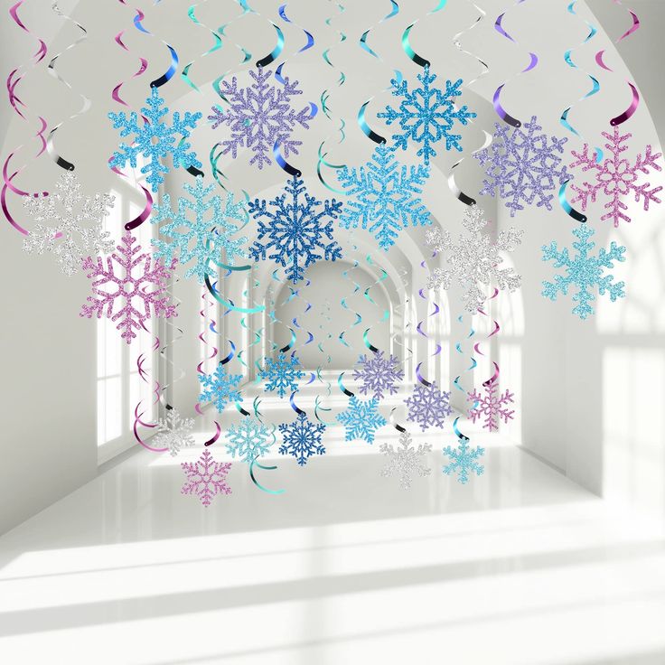 snowflakes and streamers are hanging from the ceiling in a room with white walls