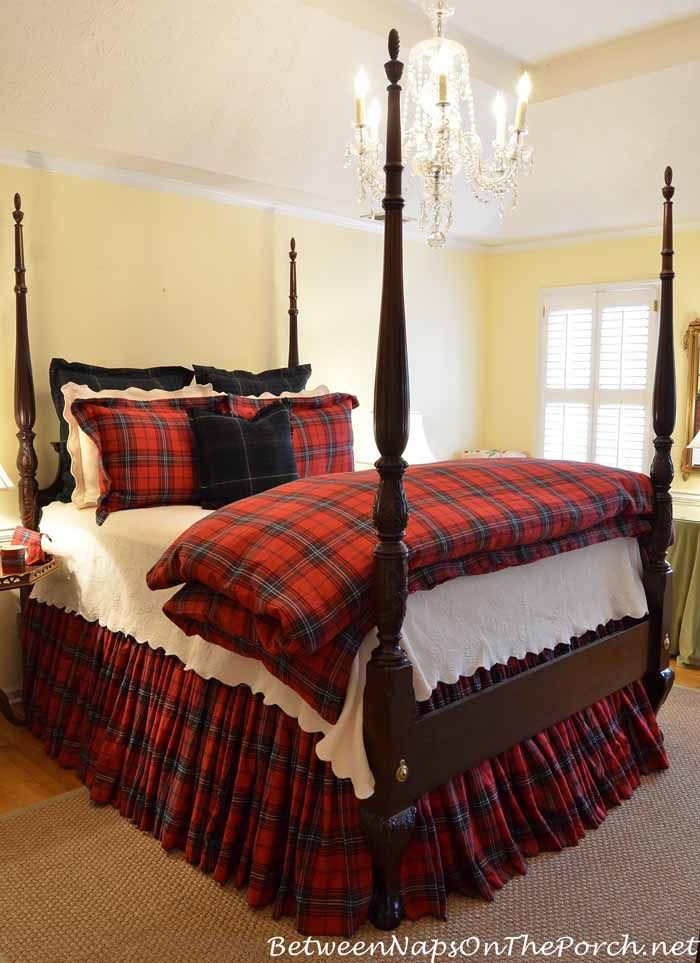 a bedroom with a four post bed and chandelier