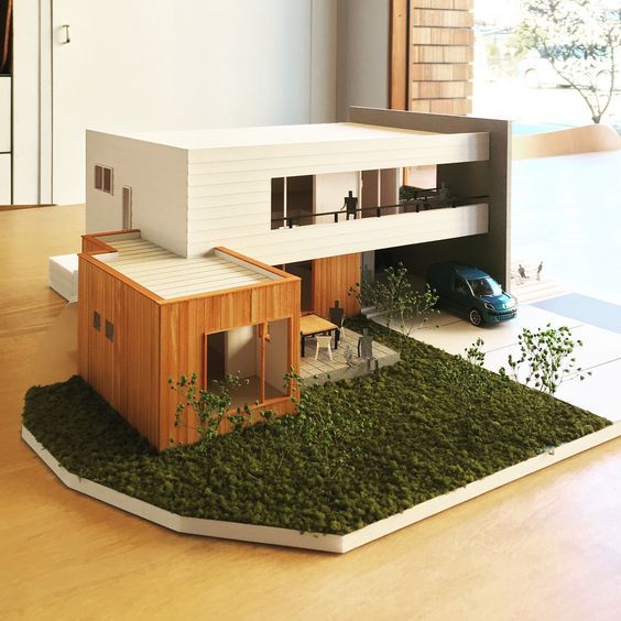 a model of a house with grass on the ground and a car parked in front of it