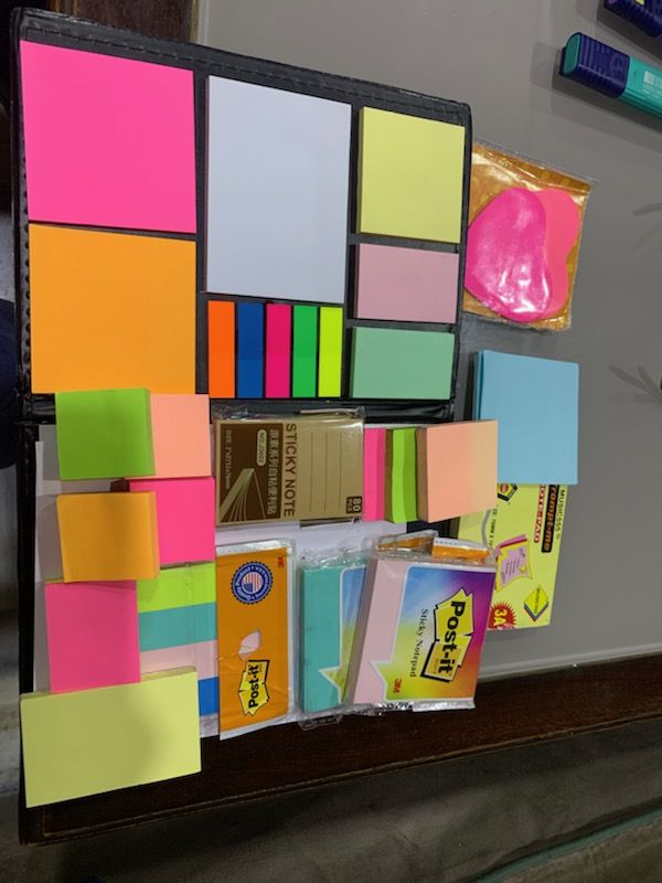 there are many different colored sticky notes on the wall