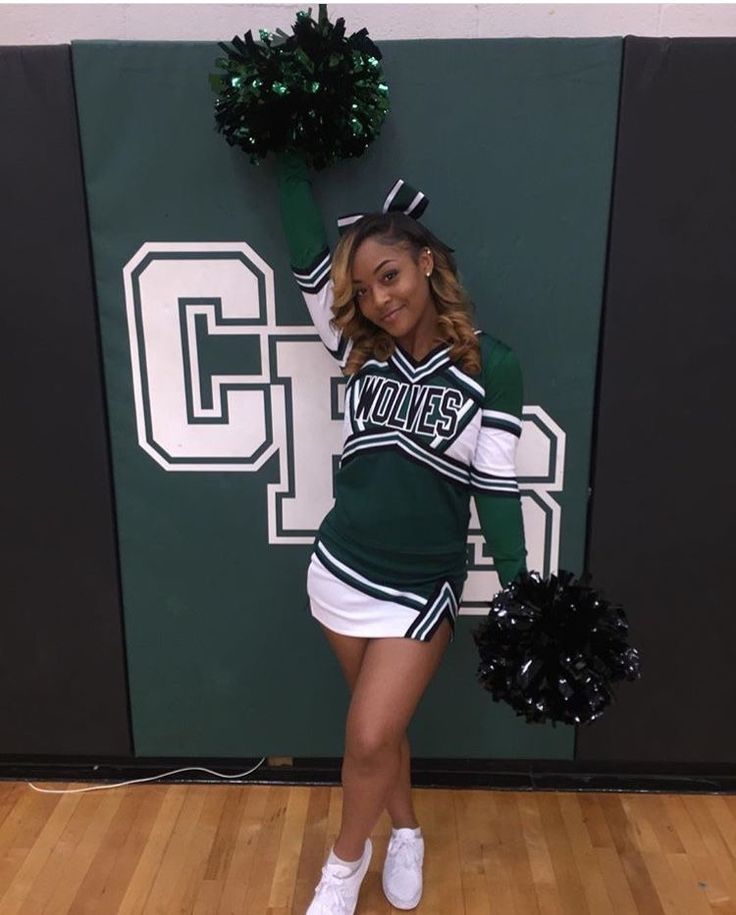 a cheerleader posing in front of a wall