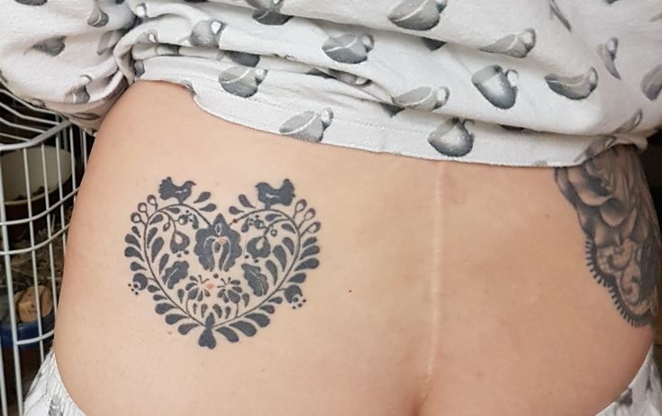 a woman's lower back with tattoos on it