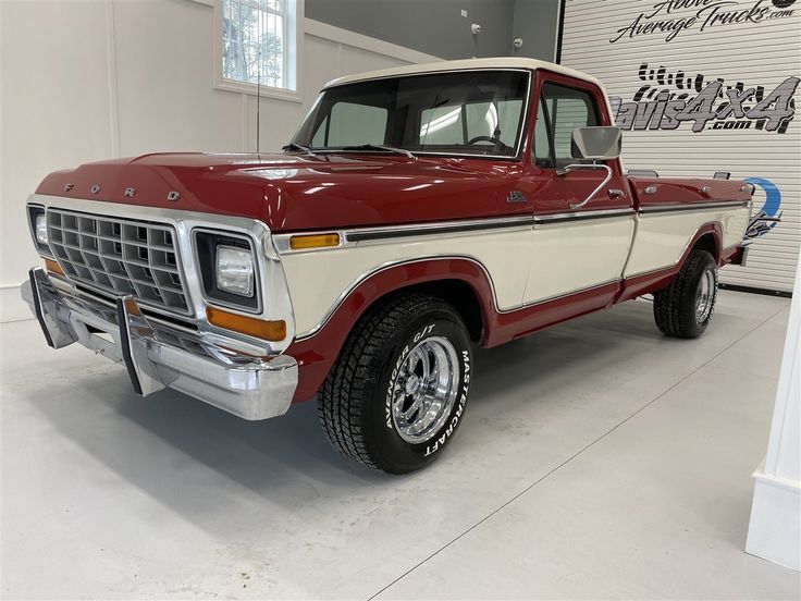 an old red and white truck parked in a garage