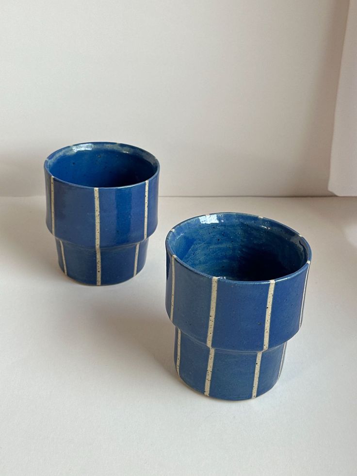 two blue cups sitting next to each other on a table