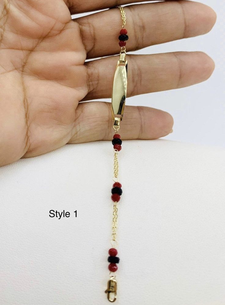 "The power of red is believed to protect children. Many legends mentioned the power of coral used as a talisman to protect newborns in Ancient Rome.  In the Hispanic culture is a tradition that babies wear a red piece of jewelry, as well. STYLE 1  Real 14k Gold Baby ID Bracelet red and black Beads  This dainty bracelet is 6\" Long  3.5mm beads    ESTILO 1  Pulsera de bebé con placa y bolitas negras y rojas.  Oro de 14 Kilates  Protección talismán de recién nacido y bebé. Este brasalete de oro mide 6 pulgadas  SKU 31269 SYLE 2 ❤️ Real 14k Gold Baby ID Bracelet red and black Beads  ❤️ This dainty bracelet is 6.5\" Long ❤️ The power of red is believed to protect children. Many legends mentioned the power of coral used as a talisman to protect newborns in Ancient Rome.  In the Hispanic culture Gift Red 14k Gold Bracelet, 14k Gold Bracelet With Polished Beads As A Gift, Black 14k Gold Bracelet As Gift, Hispanic Culture, 10k Gold Ring, Gold Armband, Dainty Bracelet, Gold Box, Id Bracelets