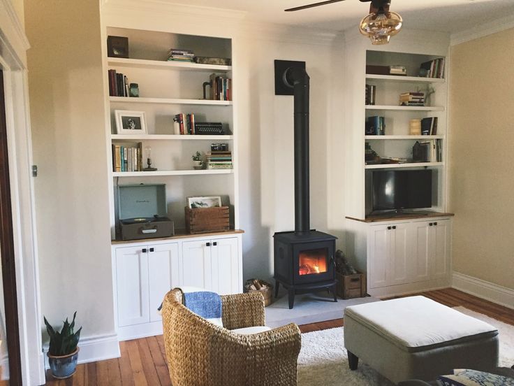 a living room filled with furniture and a fire place in the middle of it's wall