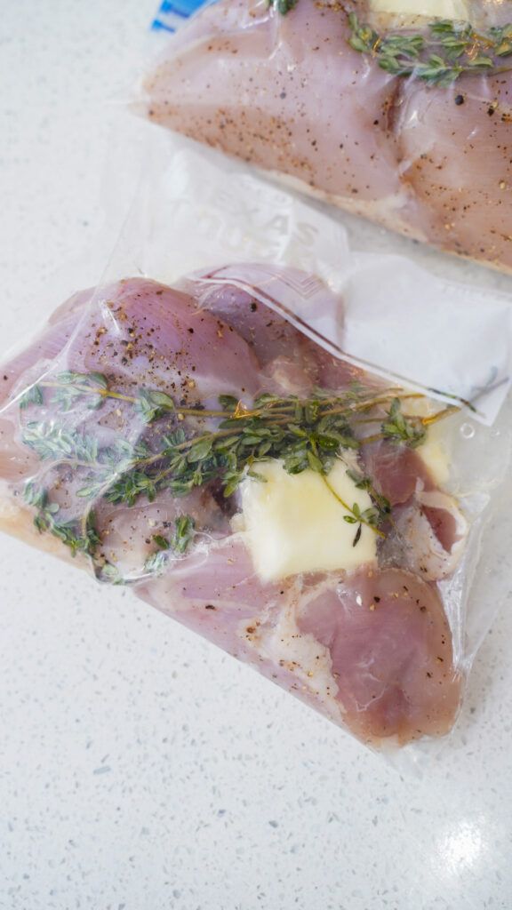 two pieces of meat wrapped in plastic sitting on a counter