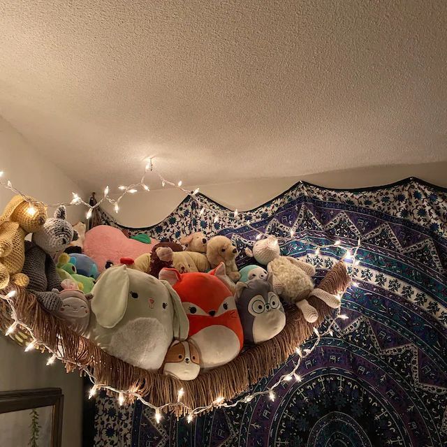 there are many stuffed animals in the middle of this room with lights hanging from the ceiling