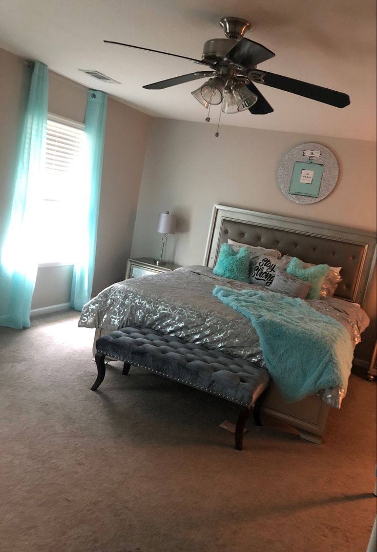 a bedroom with a large bed and ceiling fan