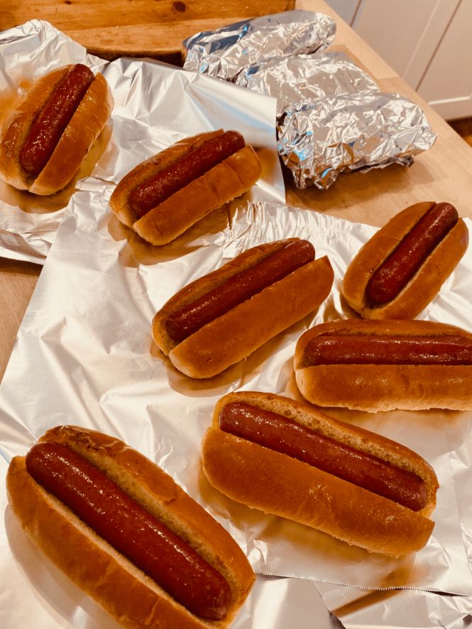 six hotdogs sitting on top of aluminum foil