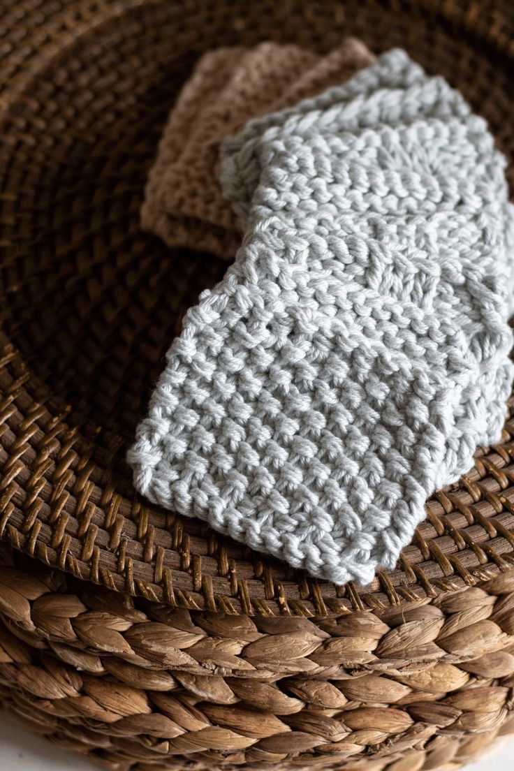 a knitted white tie sitting on top of a woven basket next to a napkin