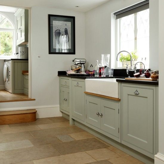 a kitchen filled with lots of counter top space and white cabinets next to a stair case