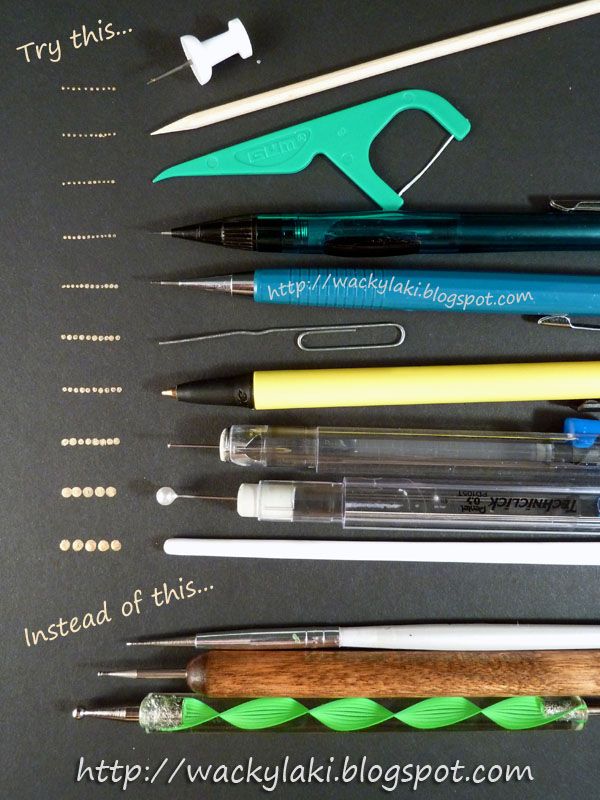 several pens and pencils sitting on top of a black board