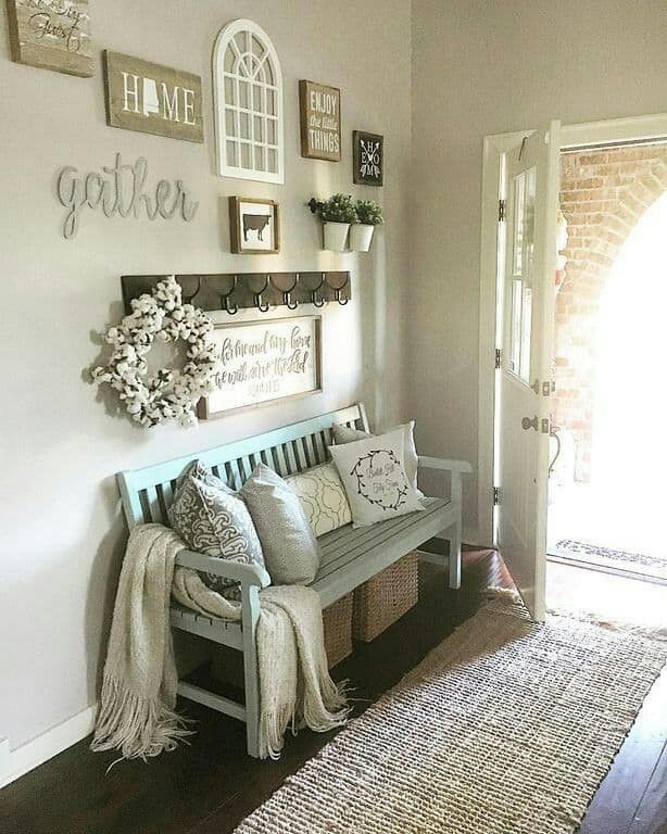 a wooden bench sitting in front of a doorway next to a white wall with pictures on it