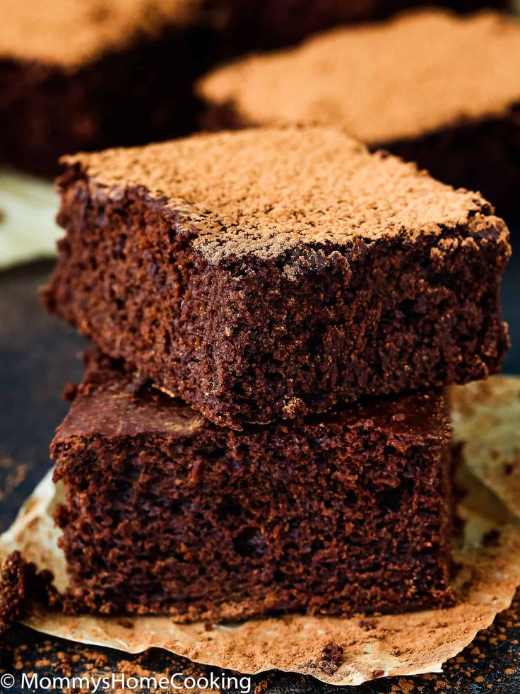 two pieces of chocolate cake sitting on top of each other next to some bread chips