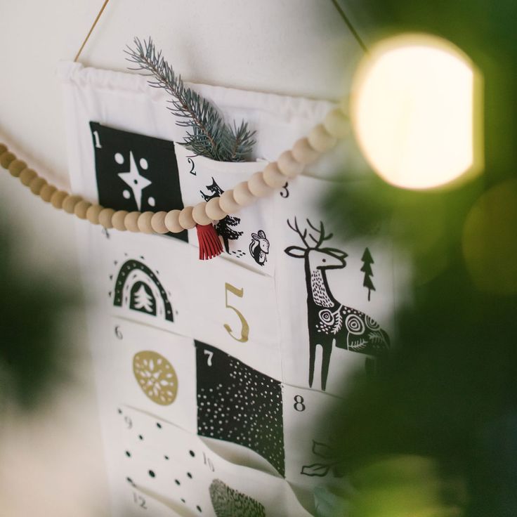 a wooden beaded necklace hanging on a wall next to a christmas tree ornament