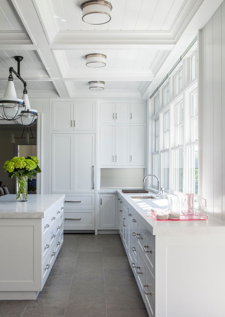 a large kitchen with white cabinets and counter tops