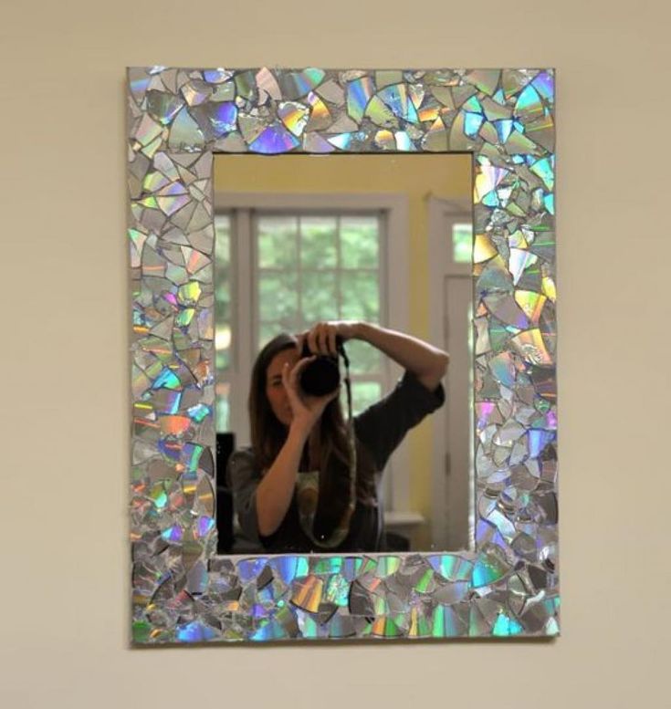 a woman taking a photo with her camera in front of a mirror that has iridescents on it