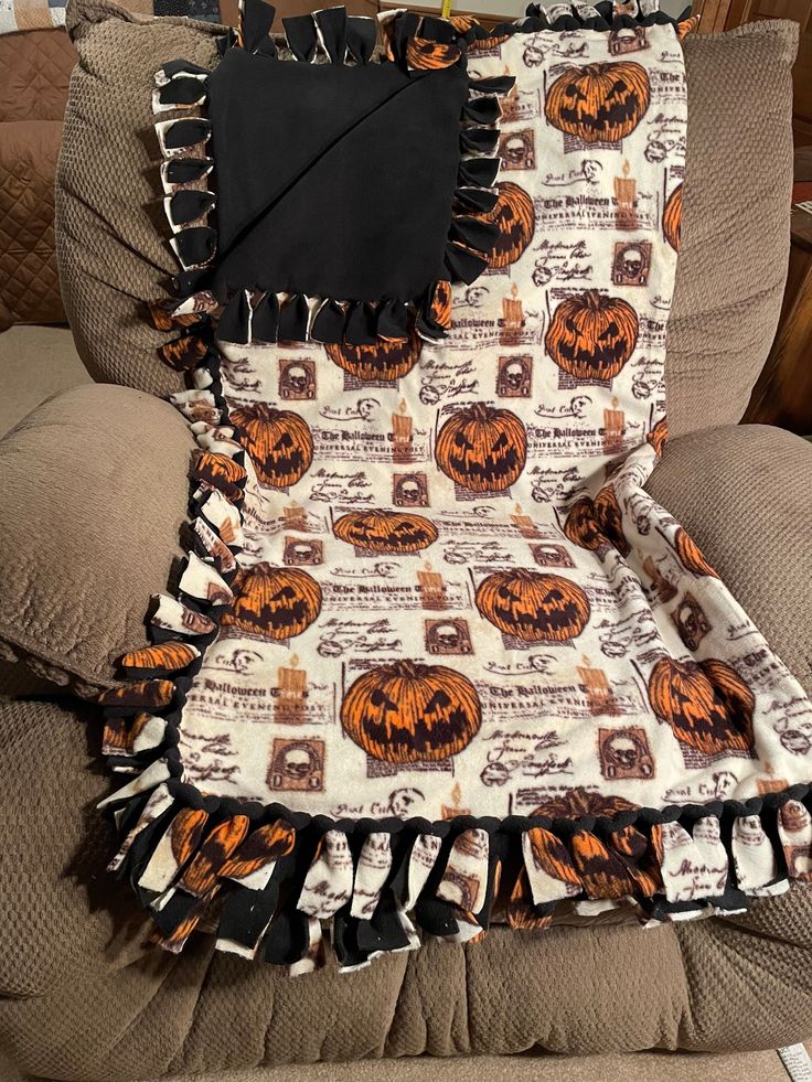 an orange and black pumpkin print blanket on a couch