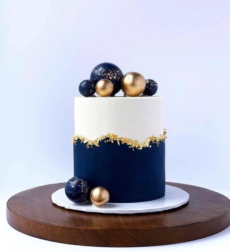 a white and blue cake with gold decorations