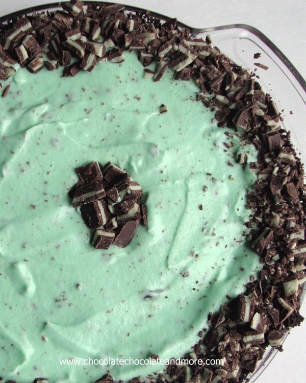 a chocolate and mint pie with white frosting in a glass pie dish on a table