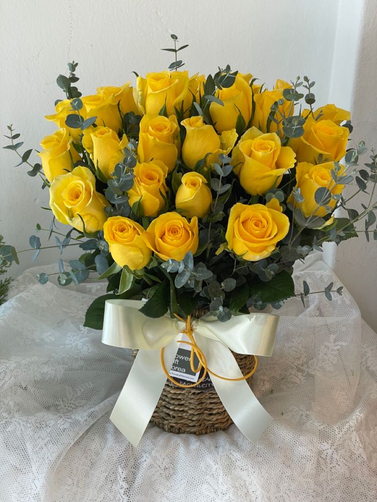 a basket filled with yellow roses on top of a table