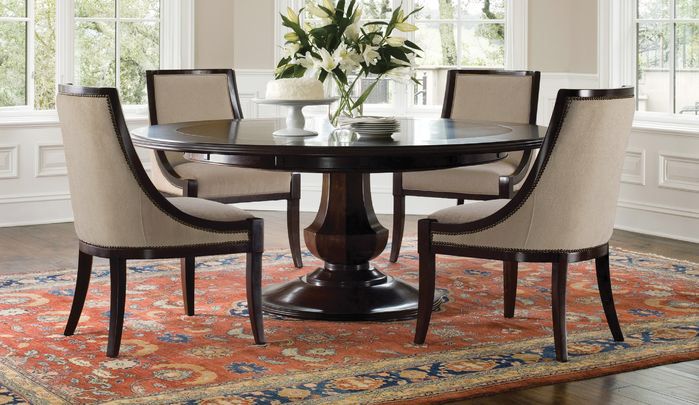 a dining room table with chairs around it and a rug in front of the table