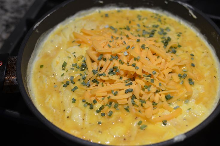 cheese and chives are in a skillet on the stove